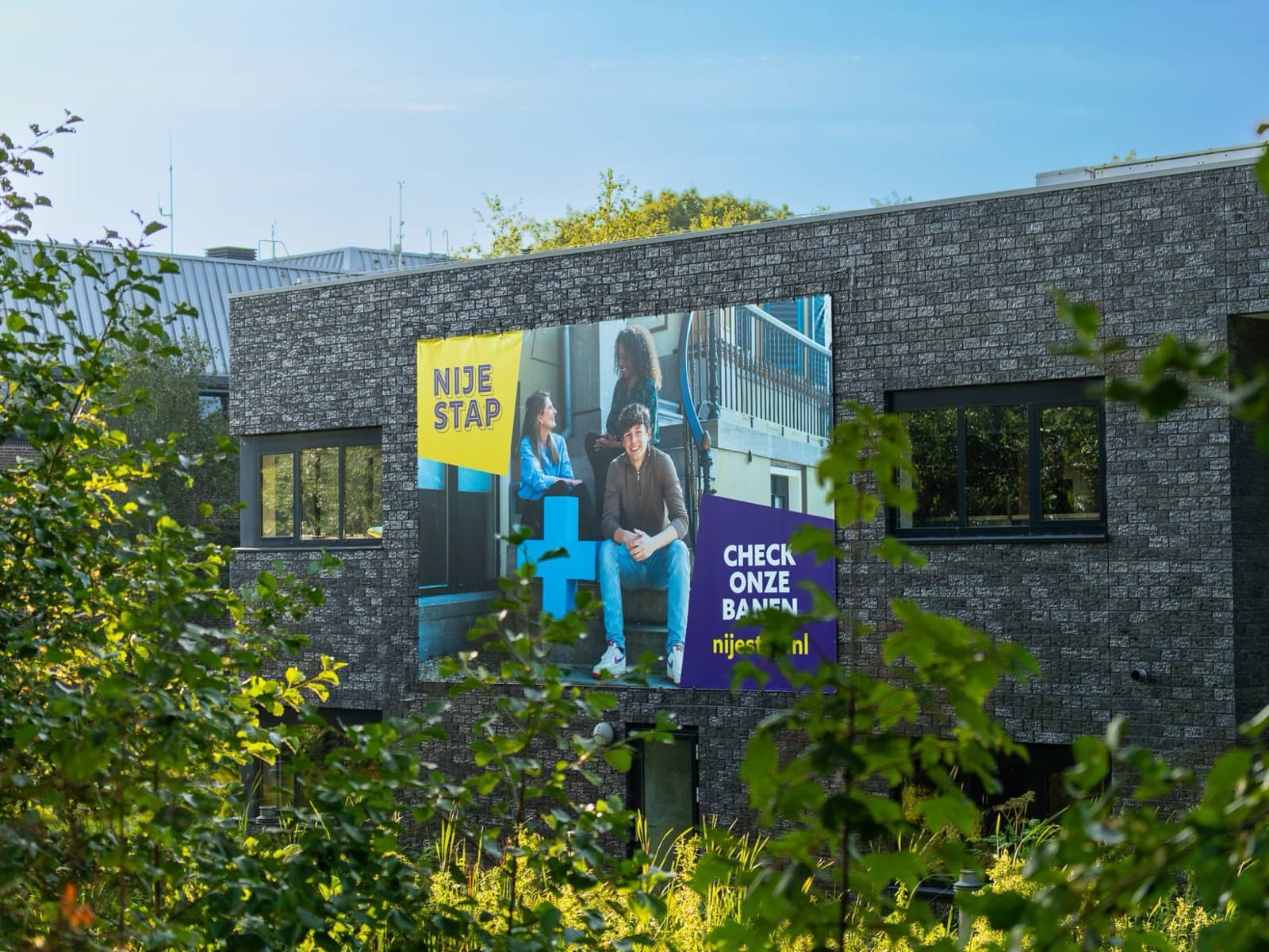Groot spandoek van Nije Stap aan de gevel van het gemeentehuis