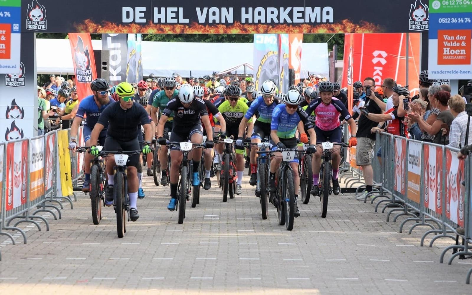 Start van De Hel van Harkema met bedrukte dranghekdoeken langs het parcours