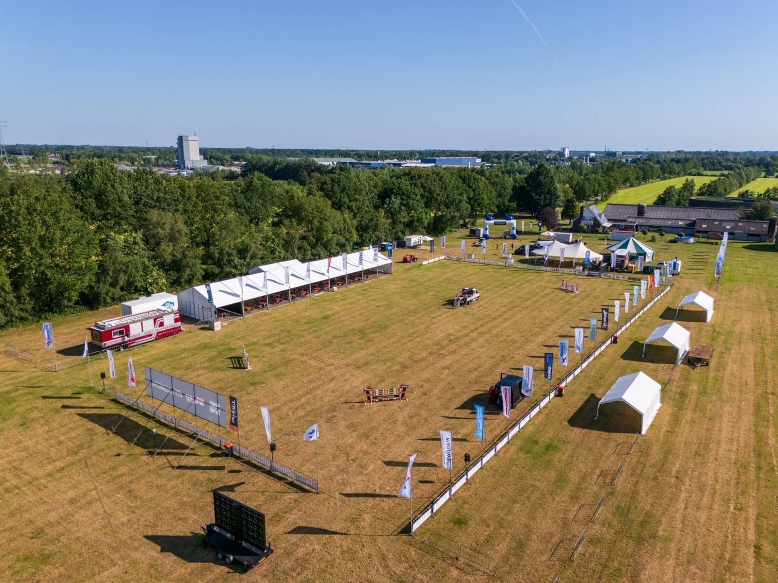 Luchtfoto van het parcours, afgezet met dranghekken met sponsordoeken en baniervlaggen