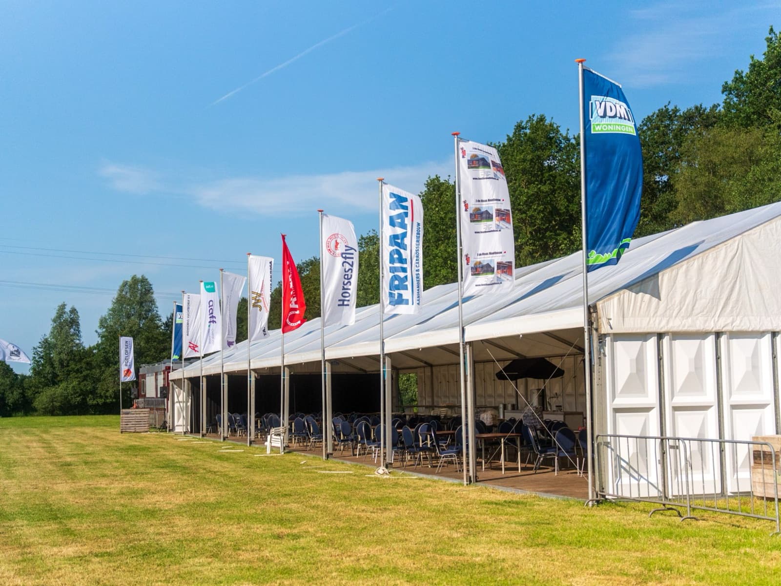 Sponsorvlaggen naast de feesttent van Concours Hippique Drogeham