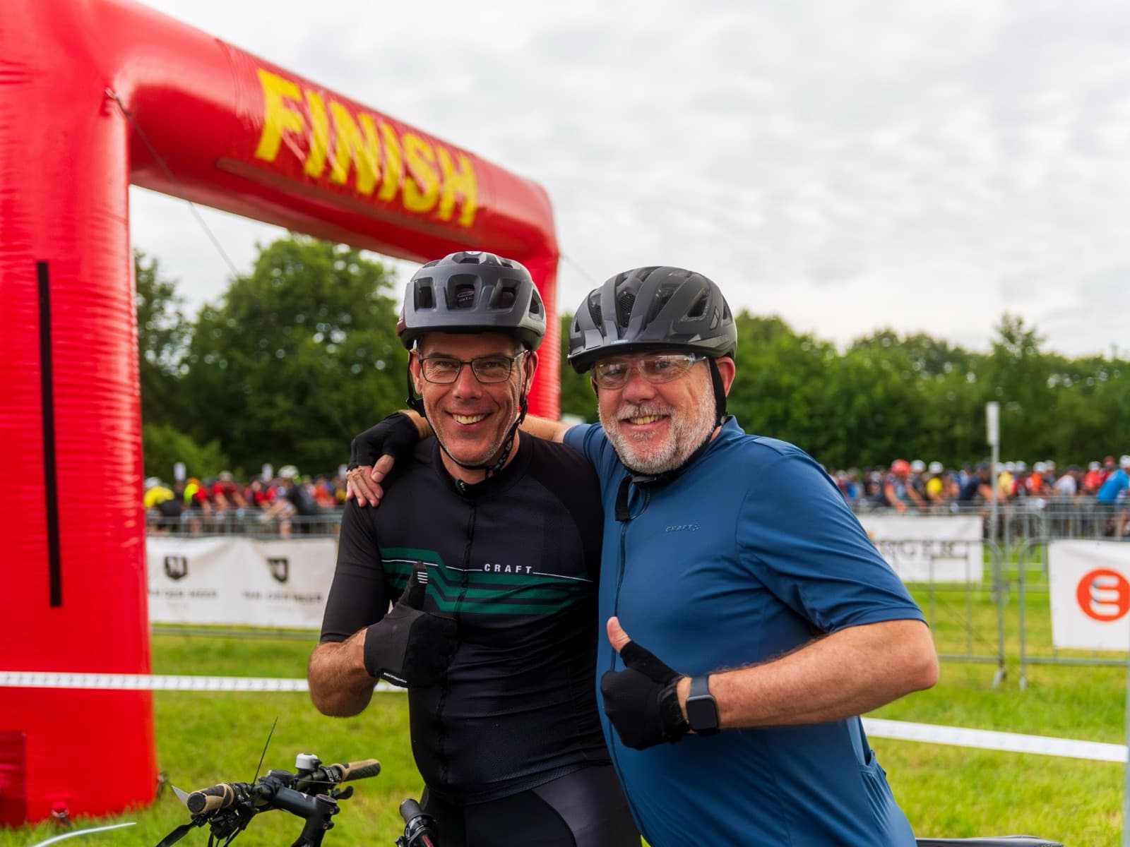 Twee lachende deelnemers bij de finishboog van De Hel van Harkema