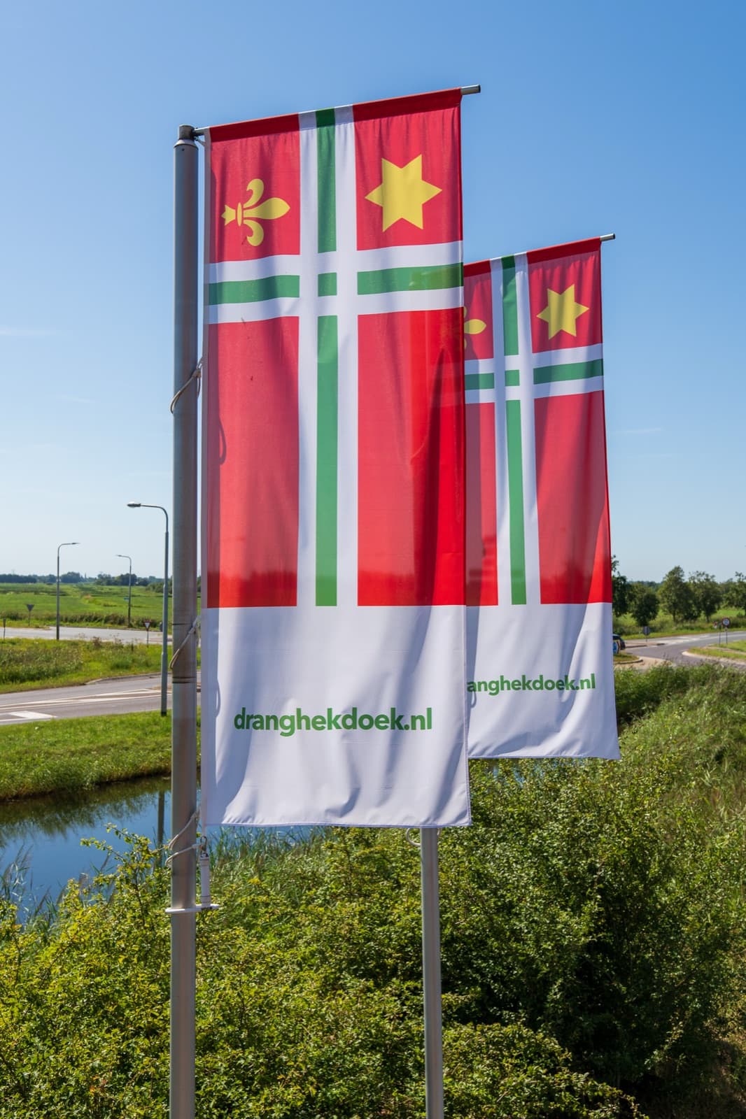Twee Dorpsvlaggen Buitenpost in de wind