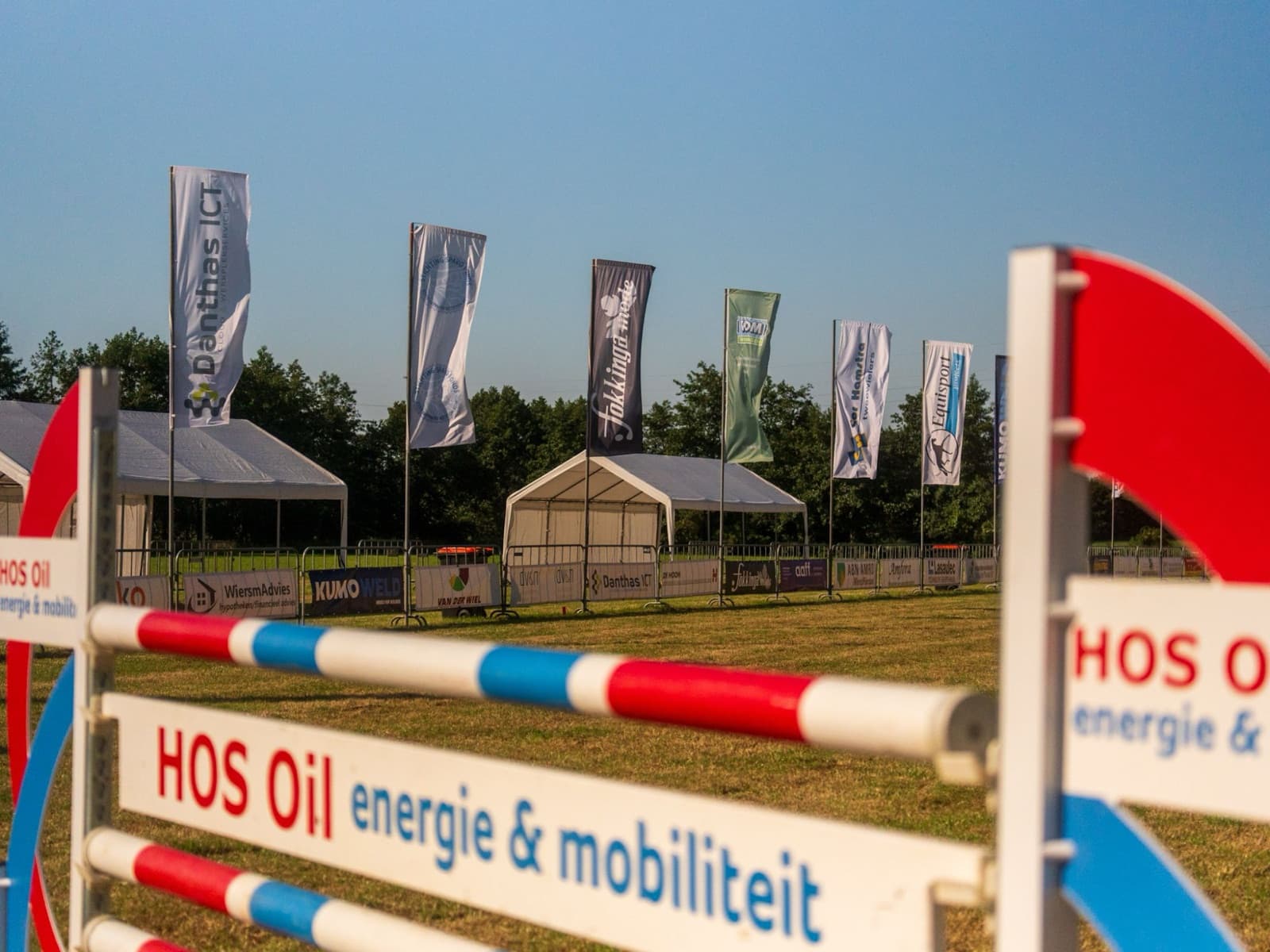Baniervlaggen van sponsors langs het parcours van een springwedstrijd